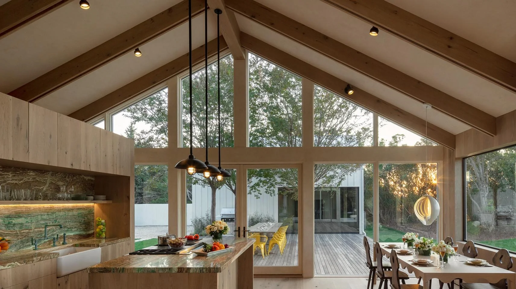 A luxury kitchen and dining space bathed in warm Lutron lighting at dusk
