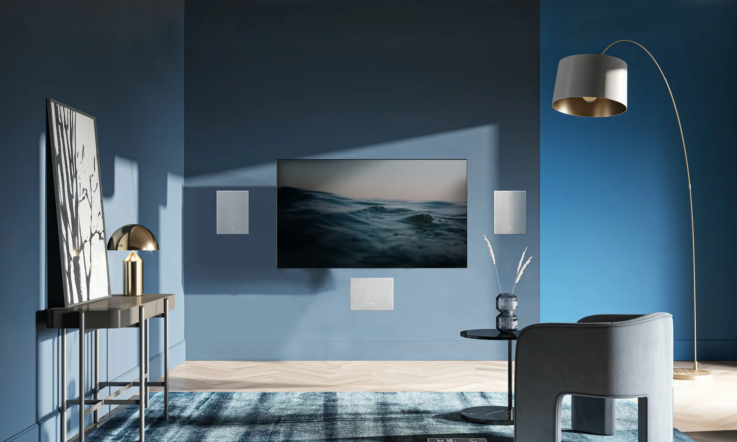 A blue media room with a television and three KEF in-wall speakers, grilles painted to the wall