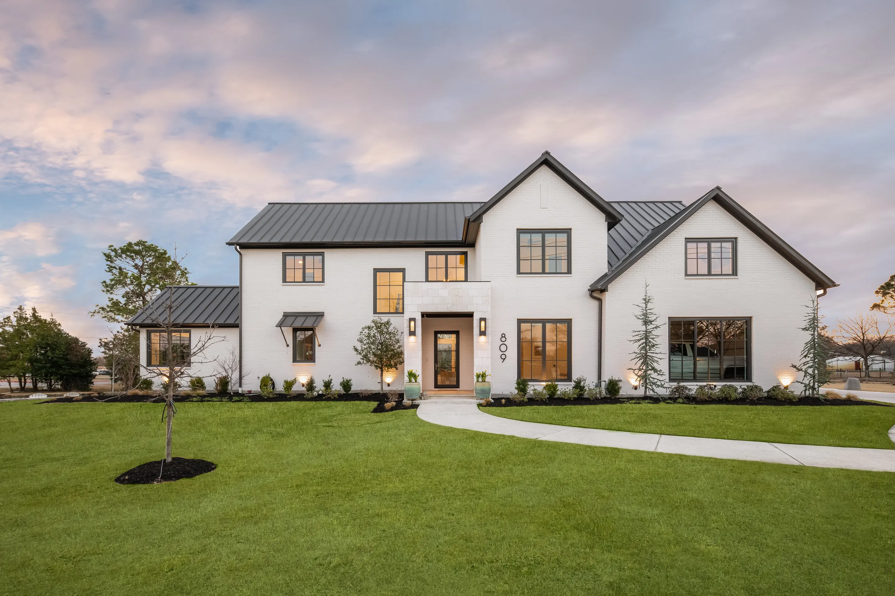 Front elevation of a custom residence in Colleyville, Texas at dusk with exterior lighting on