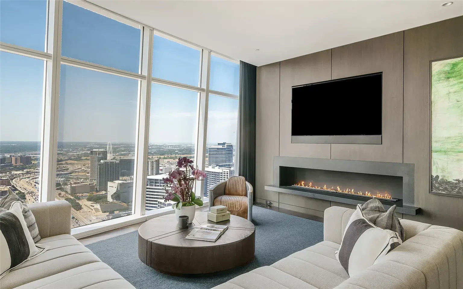 A living room with a linear fireplace and a television set flush into a paneled wall
